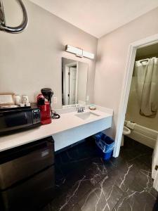 a bathroom with a sink and a microwave at Ozark Inn & Suites in Ozark +29 photos