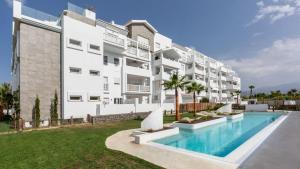 an apartment building with a swimming pool in front of it at Dos Mundos in Motril