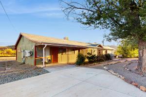 uma casa verde com uma árvore em frente em Emerald Emergence em Cornville