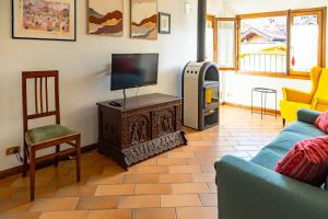 ein Wohnzimmer mit Fernseher und Sofa in der Unterkunft Chalet Carillo - 4 camere in pieno centro di Fiera di Primiero in Fiera di Primiero