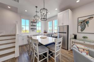 een keuken met witte kasten en een tafel en stoelen bij Port Aransas Sunset in Mustang Beach