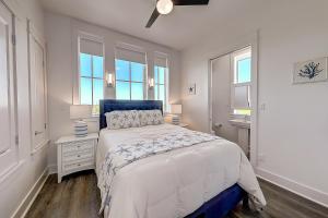 een witte slaapkamer met een bed en twee ramen bij Port Aransas Sunset in Mustang Beach +18 foto's