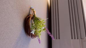a bunch of flowers hanging on a wall at Little Birds Hostel in Omihachiman