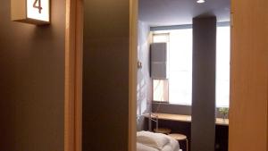 a room with a bedroom with a window and a bed at Little Birds Hostel in Omihachiman