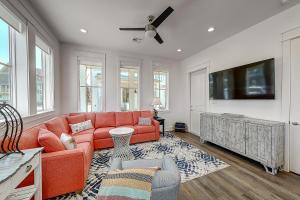 een woonkamer met een oranje bank en een flatscreen-tv bij Port Aransas Sunset in Mustang Beach