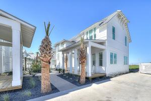 een wit huis met palmbomen ervoor bij Port Aransas Sunset in Mustang Beach