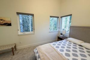 ein Schlafzimmer mit einem Bett und zwei Fenstern in der Unterkunft Silver Tip Condo in Girdwood Airport