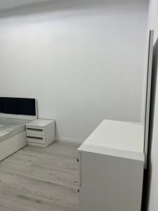 米特罗维察City View Apartment的一间带床和书桌的白色房间