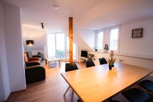 a dining room and living room with a table and chairs at Evelyns Apartment, nahe der Therme und dem Zentrum, privat Parkplatz, Balkon, Highspeed-WLAN in Bad Kissingen