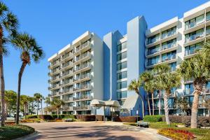 Bayside at Sandestin 6681 في ديستين: مبنى كبير أمامه أشجار النخيل