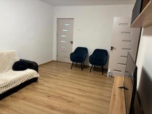 a living room with two chairs and a couch at Urban apartament in Craiova