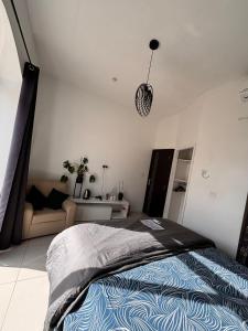 a bedroom with a bed and a couch at Next to beach Sliema Stay, Cozy, Air-Conditioned, Self Check-In in Il-Gżira