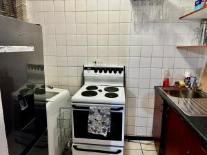 una piccola cucina con fornelli e lavello di Feel At Home Cosy Apartment a Gaborone