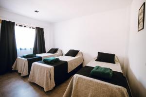 a room with three beds with green pillows on them at Complejo Malama Kai in Mar de Cobo +21 photos
