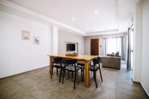 een woonkamer met een houten tafel en stoelen bij Complejo Malama Kai in Mar de Cobo