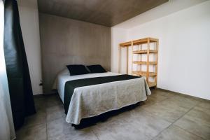 een slaapkamer met een bed en een boekenplank bij Complejo Malama Kai in Mar de Cobo +20 foto's