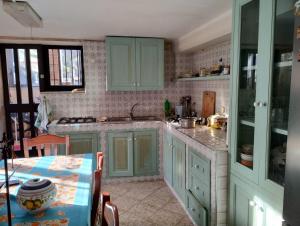 a kitchen with green cabinets and a table in it at I Giardini di Palazzo Ducale in Pietramelara