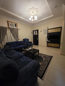 a living room with blue couches and a television at مسكن راحتك للشقق المخدومه in Tabuk