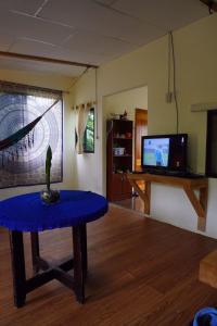 a living room with a table and a tv at Shark House in Bellavista