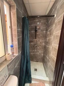 a shower with a blue shower curtain in a bathroom at Next to beach Sliema Stay, Cozy, Air-Conditioned, Self Check-In in Il-Gżira