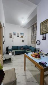 ein Wohnzimmer mit einem Sofa und einem Tisch mit einem Obstteller in der Unterkunft Lisi apartment in Tirane