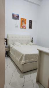 ein weißes Schlafzimmer mit einem Bett und einem Tisch in der Unterkunft Lisi apartment in Tirane