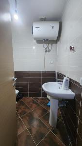 ein Badezimmer mit einem weißen Waschbecken und einer Toilette in der Unterkunft Lisi apartment in Tirane
