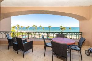 een balkon met een tafel en stoelen en de oceaan bij Sonoran Spa W409 in Campo del Medio