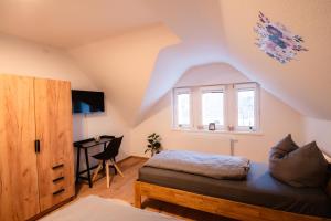 a attic bedroom with a bed and a desk at Evelyns Apartment, nahe der Therme und dem Zentrum, privat Parkplatz, Balkon, Highspeed-WLAN in Bad Kissingen