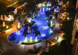 Una vista aérea de una piscina en un resort por la noche. en Jaco Bay, en Jacó