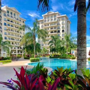 un complejo con una piscina con palmeras y edificios en Jaco Bay, en Jacó
