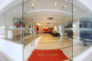 a glass corridor with a welcome sign in a building at Hotel Min Cott in Kuala Lumpur