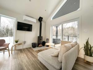 un salon avec un canapé et une cheminée dans l'établissement Le Soren, à Sainte Béatrix