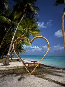 a heart shaped sign on a beach with a bench at Eco Palm Maldives in Mathiveri