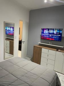 une chambre avec un lit et une télévision à écran plat dans l'établissement Espacio 48, à La Plata