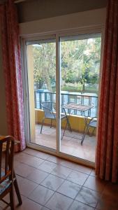Zimmer mit einer Glasschiebetür und einem Tisch in der Unterkunft Parque 20 in Ayamonte