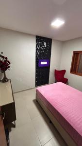 Un dormitorio con una cama rosa y un televisor en la pared. en BLEND Work, en Nova Hartz 4 fotos más