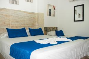 une chambre avec deux lits avec des draps bleus et blancs dans l'établissement Hostal Kumbaya, à Santa Marta 20 autres photos
