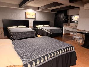 una habitación con tres camas y una mesa y un escritorio en Hotel Mirage Express, en Matamoros 31 fotos más
