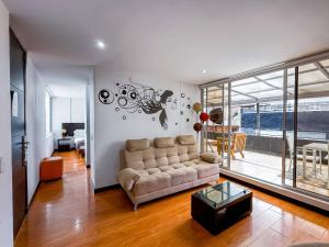 a living room with a couch and a table at Hotel Regency Suites La Feria in Bogotá