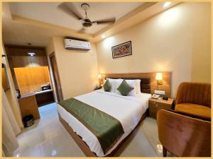 a hotel room with a bed and a chair at Rooftop SEA VIEW - SWIMMING POOL - Hotel The LB Resort Sea View Hotel Near Jagannath Temple - Parking And Resturent - Breakfast Included - A Fully Air Conditioning Luxuary Rooms - Top service in Puri