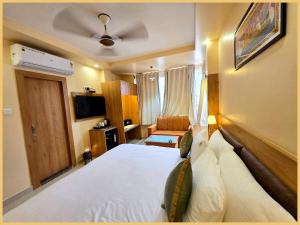 a hotel room with a large bed and a television at Rooftop SEA VIEW - SWIMMING POOL - Hotel The LB Resort Sea View Hotel Near Jagannath Temple - Parking And Resturent - Breakfast Included - A Fully Air Conditioning Luxuary Rooms - Top service in Puri