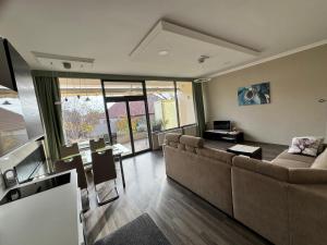 een woonkamer met een bank en een tafel bij LUX Apartman in Balatonfüred
