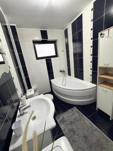 a black and white bathroom with a tub and a sink at Modern apartment in Ford-Ferval area, Craiova in Craiova