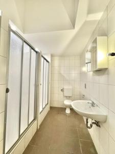 a white bathroom with a sink and a toilet at Casa Heusenstamm in Heusenstamm