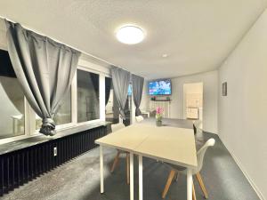 a dining room with a table and two windows at Casa Heusenstamm in Heusenstamm