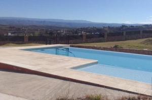 une grande piscine bleue au sommet d'une colline dans l'établissement Vivaldi 192 Villa Carlos Paz, Córdoba, à Villa del Lago