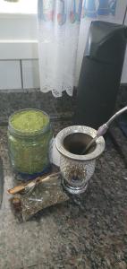 Ein Mörser mit Stößel steht auf der Arbeitsfläche neben einem Glas grüner Soße. in der Unterkunft Omma's Haus - Casa de Vó perto de Gramado in Morro Reuter