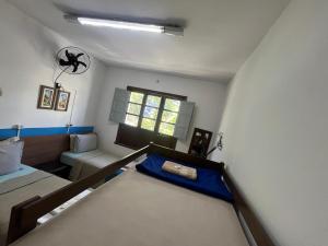 ein Schlafzimmer mit einem Bett und einer Couch und einem Fenster in der Unterkunft Rota BH Hostel in Belo Horizonte