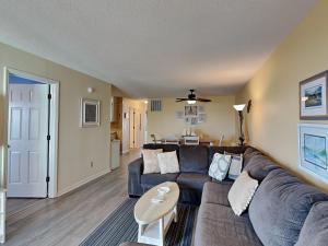 een woonkamer met een bank en een tafel bij Winds V1 #3B - My Top Paradise in Carolina Beach